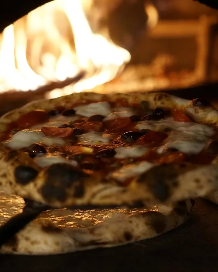 Una pizza appena sfornata davanti alle fiamme del forno a legna – La Vecchia Rama, Negrar